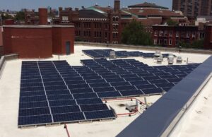 Array of flat roof solar panels on brick building
